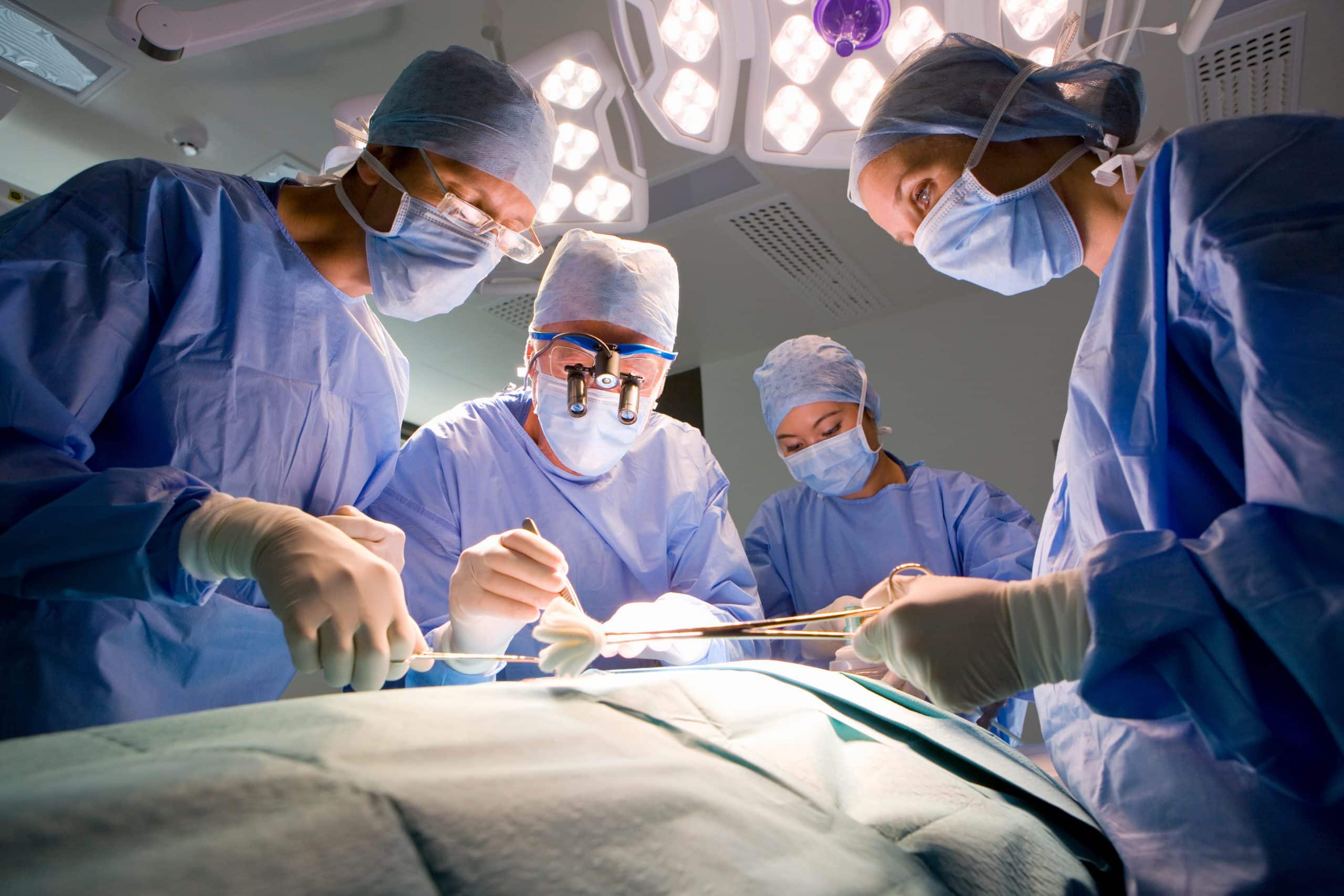 Surgeon and medical staff working on patient in operating room
